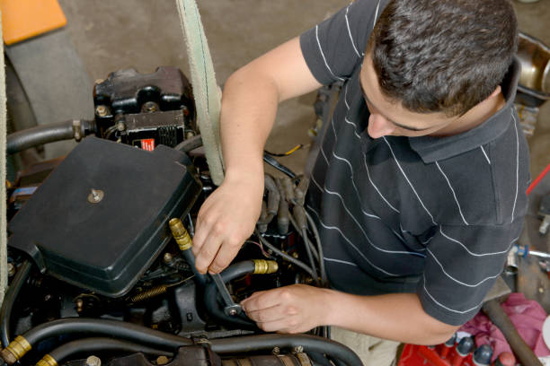 A young man mechanic repairing motor boats and other